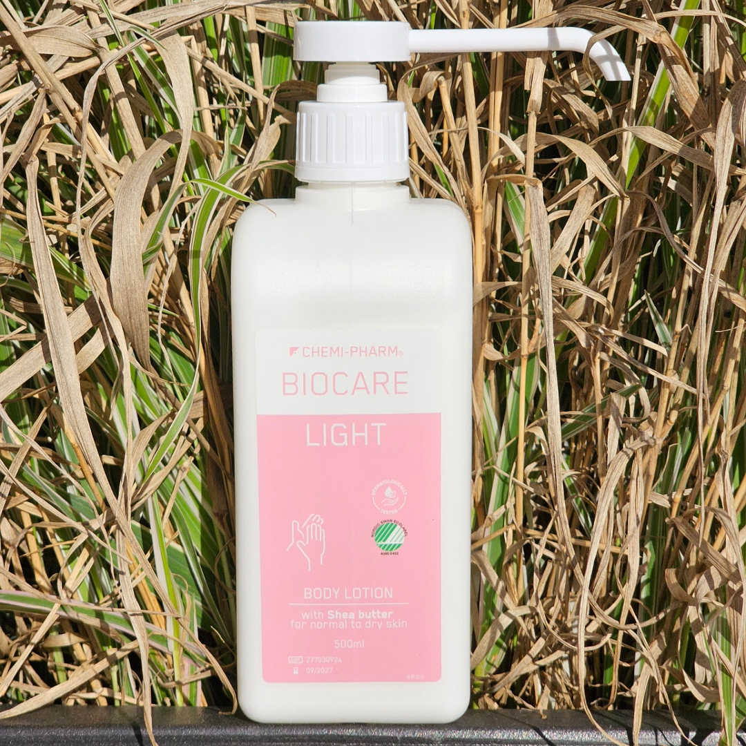 Biocare Light kerge 15% kätekreem roosas pumppudelis kõrtega taustal